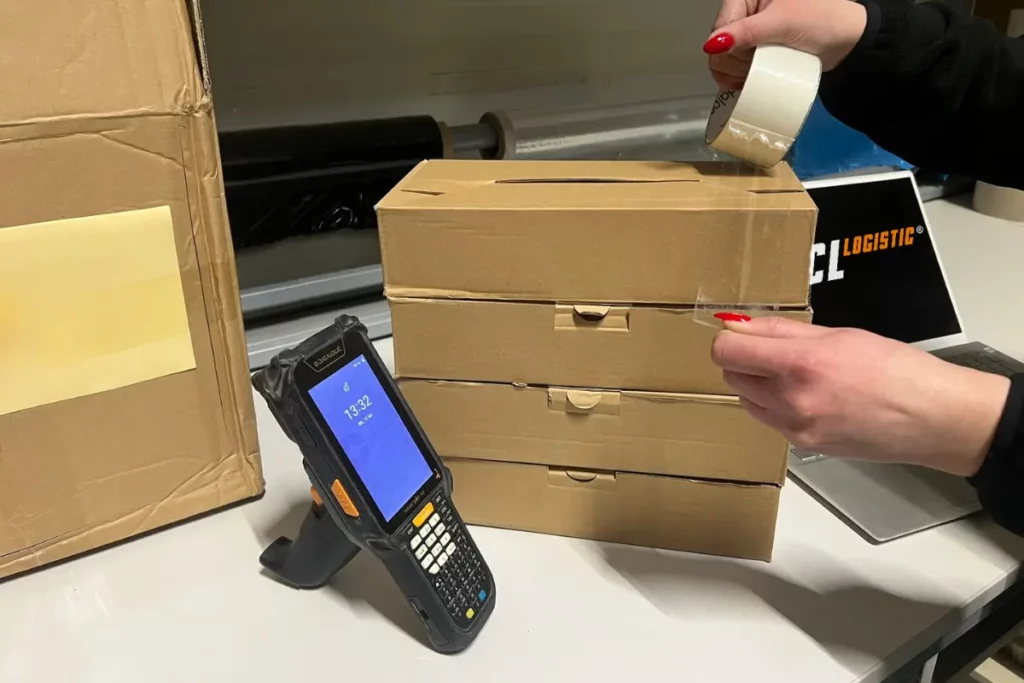 Pracownik LCL Logistic zakleja karton. Praca zgodnie z Lean Logistics